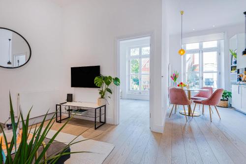 a white living room with a table and chairs at Lady on the Lane- 2 bed Primrose Hill in London