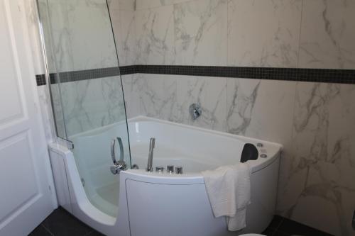 a white bath tub in a bathroom with a shower at Pinna Nobilis Apartments - Ground Floor in Brodarica
