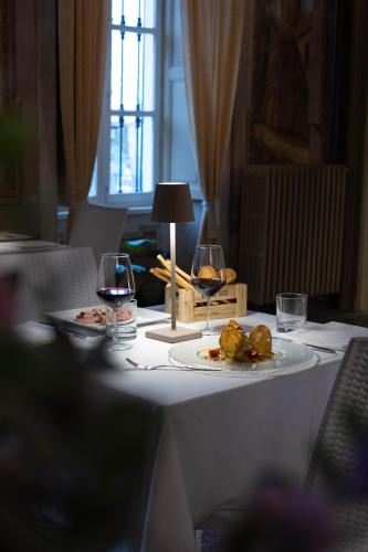 a table with two glasses of wine and a plate of food at Agriturismo Podere La Piazza in Costigliole dʼAsti