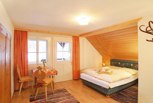 a bedroom with a bed and a desk and a window at Großmitt in Pertisau