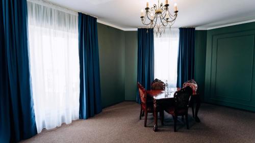 a dining room with a table and blue curtains at Globus Hotel in Ternopilʼ