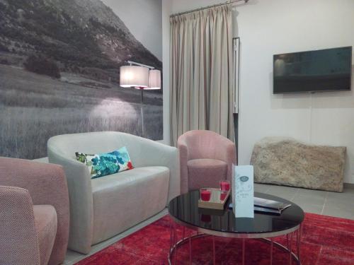 a living room with a couch and a table and a tv at Monsanto GeoHotel Escola in Monsanto