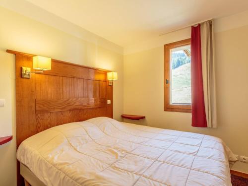 une chambre avec un grand lit et une fenêtre dans l'établissement La Plagne, 5 pers, balcon, animaux admis - FR-1-353-115, à La Plagne Tarentaise