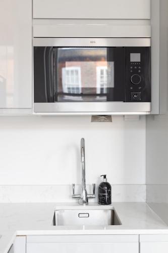 a microwave above a sink in a kitchen at Hampstead High Flyer in London