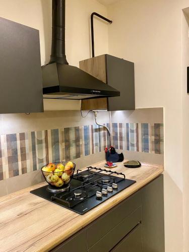 a kitchen with a stove and a bowl of fruit at Dez Guest House, Margahovit, Lori in Margahovit