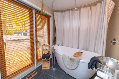 a bathroom with a large tub and a window at Cozy Cabin Retreat Hot Tub and Fire Pit in Innisfil