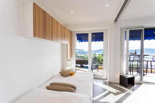 une chambre avec un lit et de grandes fenêtres dans l'établissement Esterel AP4431 By Riviera Holiday Homes, à Villefranche-sur-Mer