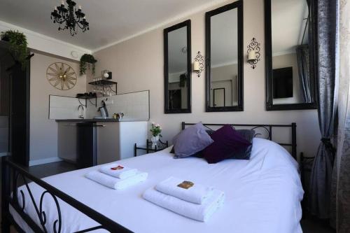 une chambre avec un lit blanc avec deux serviettes dessus dans l'établissement Orphelin2 balnéo plaisir & détente au centre ville, à Reims