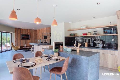 une cuisine avec une table et des chaises dans une pièce dans l'établissement Villa Arvernha, à Chambon-sur-Lac