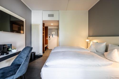 a bedroom with a large white bed and a tv at Dresdner Tor Süd in Wilsdruff