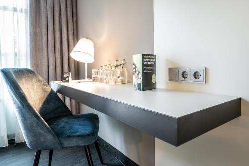a desk with a chair and a lamp in a room at Dresdner Tor Süd in Wilsdruff