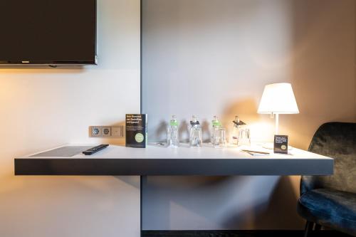 a room with a table with a lamp and a chair at Dresdner Tor Süd in Wilsdruff