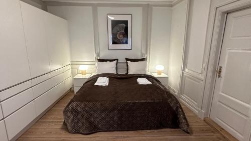 a bedroom with a large bed with two lamps at The Admirals Apartments 1 & 2 in Copenhagen