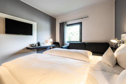 a hotel room with a bed and a couch at Dresdner Tor Süd in Wilsdruff