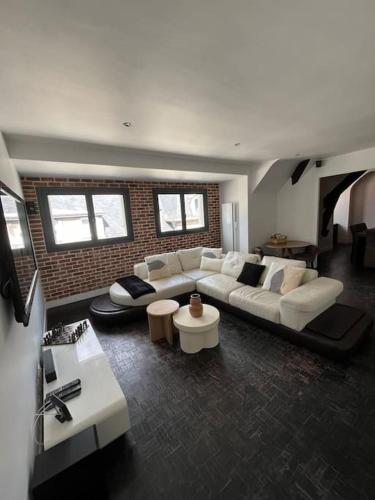 - un salon avec un canapé blanc et un mur en briques dans l'établissement Le petit Refuge - hyper centre Compiegne, à Compiègne