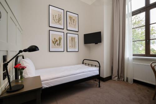 a bedroom with a bed and a desk and a window at ARCHE Klasztor Wrocław in Wrocław