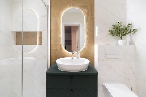 a bathroom with a sink and a mirror at Sosnowy "6", blisko centrum, w otoczeniu lasu in Kielce