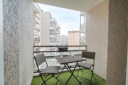 un balcon avec une table et des chaises sur un immeuble dans l'établissement Charmant et Chaleureux proche Tête d'Or, à Villeurbanne