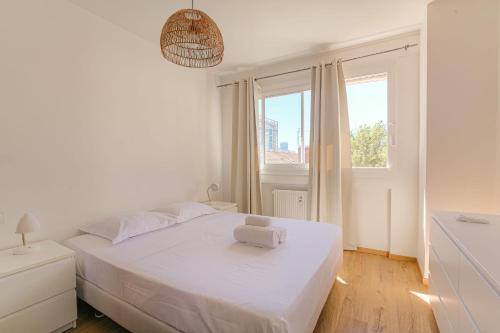 une chambre blanche avec un lit blanc et une fenêtre dans l'établissement Charmant et Spacieux avec vue à 1 min de Tête d'Or, à Lyon