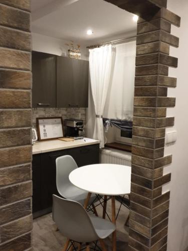 a small kitchen with a white table and chairs at Lucy's Place in Wejherowo