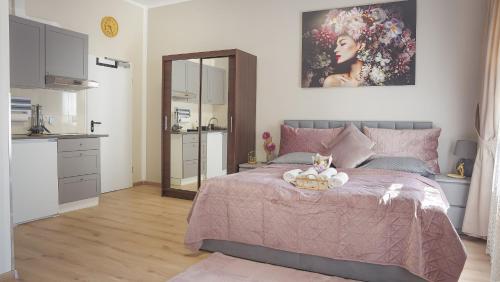 a bedroom with a pink bed with a teddy bear on it at Amir Deluxe Motel in Schönefeld