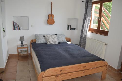 a bedroom with a wooden bed with a blue blanket at Repülőhal Apartmanház in Zebegény