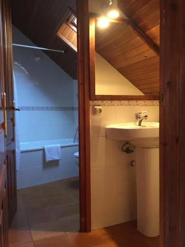 een badkamer met een wastafel, een toilet en een spiegel bij Estudi Casa Xulla in Taull