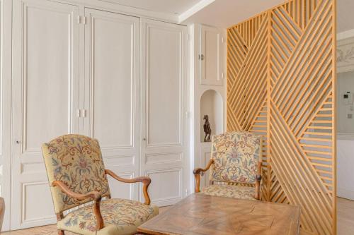 une chambre avec deux chaises et une table dans l'établissement Spacieux et Charmant 150m2 Place Maréchal Lyautey, à Lyon
