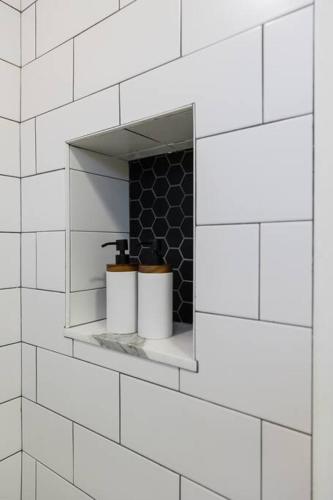 a white tiled bathroom with two toilets on a shelf at Harty's Terrace 9 Kimball Avenue in Yonkers
