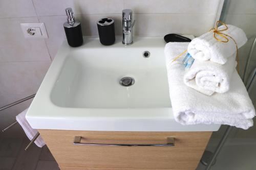 a white sink in a bathroom with towels on it at Miko Apartment by Quokka 360 - flat in Legnano in Legnano