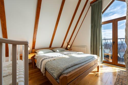 a bedroom with a bed and a large window at Vila Sun forest in Žabljak