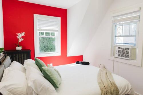 a bedroom with a white bed with a red wall at Harty's Terrace 9 Kimball Avenue in Yonkers
