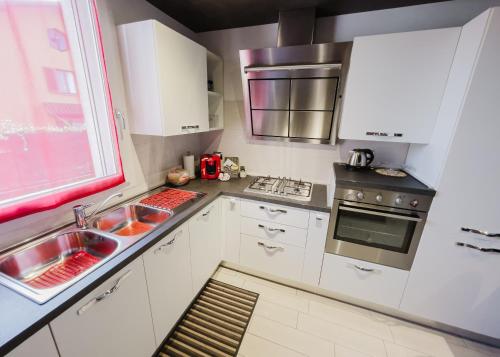 a kitchen with white cabinets and a sink and a window at La Primula by Quokka 360 - flat outside the city of Como in Tavernerio