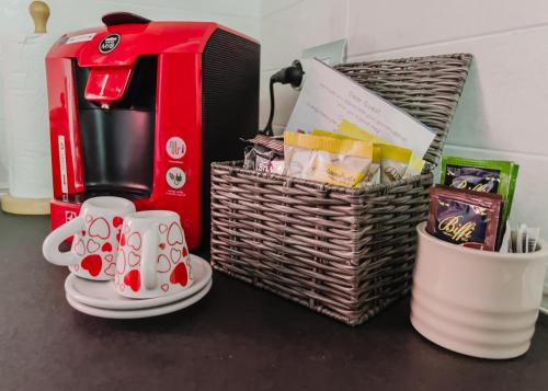 a table with a coffee maker and a basket with mugs at La Primula by Quokka 360 - flat outside the city of Como in Tavernerio