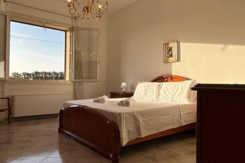 a bedroom with a bed and a large window at West Sicily - Villa with Garden and Parking in Marsala