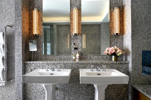 a bathroom with two sinks and a mirror at The Soho Hotel, Firmdale Hotels in London