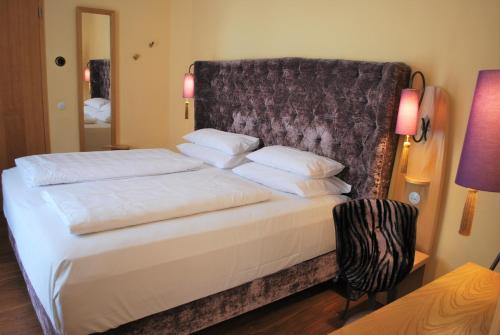 a bed with white sheets and pillows in a room at Classic Hotel Harmonie in Cologne