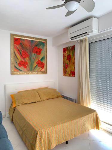 une chambre avec un lit et un tableau au mur dans l'établissement Relax Au Soleil - Proche de la plage 100 m - Centre-ville, à Menton