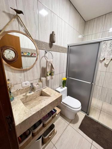 a bathroom with a sink and a toilet and a shower at Casa da Ilha in Ribeirão Claro