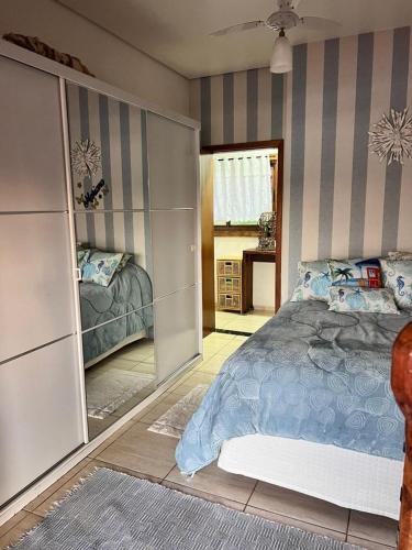 a bedroom with a bed and a mirror at Casa da Ilha in Ribeirão Claro