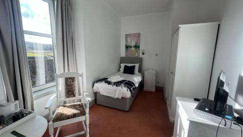 a small bedroom with a bed and a window at Hotel Square in Tomintoul