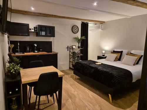 une chambre avec un lit et une table et une cuisine dans l'établissement Gîte érotique avec spa privatif, à Donzère