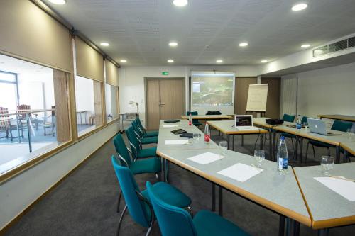 a conference room with tables and blue chairs at Logis Auberge Du Mehrbachel - Hôtel & Restaurant in Saint-Amarin