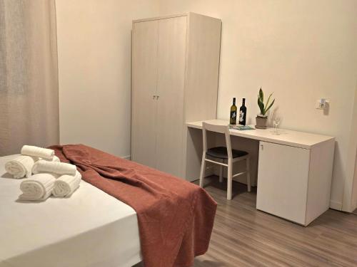 a bedroom with a bed and a desk with bottles of wine at Locanda al Sole - Vo' in Vo Euganeo