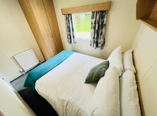 a bed in a small room with a window at 3 bedroom caravan 14 kingsgate in Shanklin