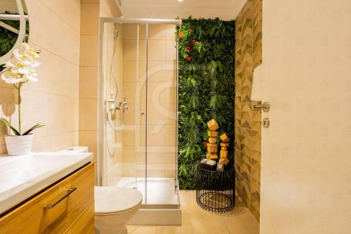 a bathroom with a shower and a toilet and a plant at Atlas by Kristal Collection in Bucharest