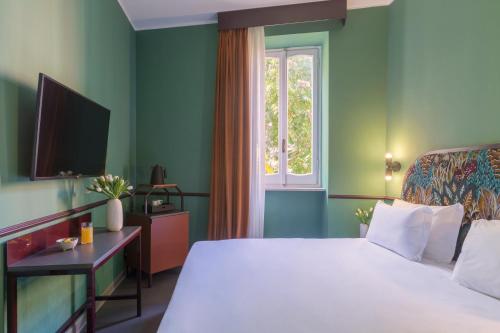 a bedroom with a white bed and a window at Barberini Retreat Boutique Hotel in Rome