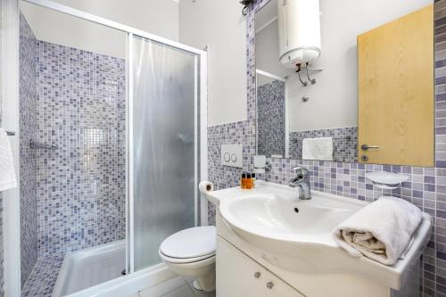 a bathroom with a sink and a toilet and a shower at Residence Kamenjak Center in Premantura