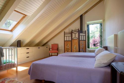 a bedroom with a large bed in a attic at Finca La Machota Centro de Naturaleza in Peralejo