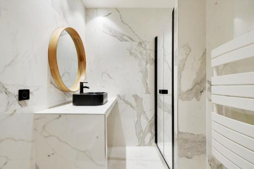 une salle de bain avec un lavabo et un miroir dans l'établissement Pick A Flat's Apartment in Place Vendôme - Rue Saint-Honore, à Paris